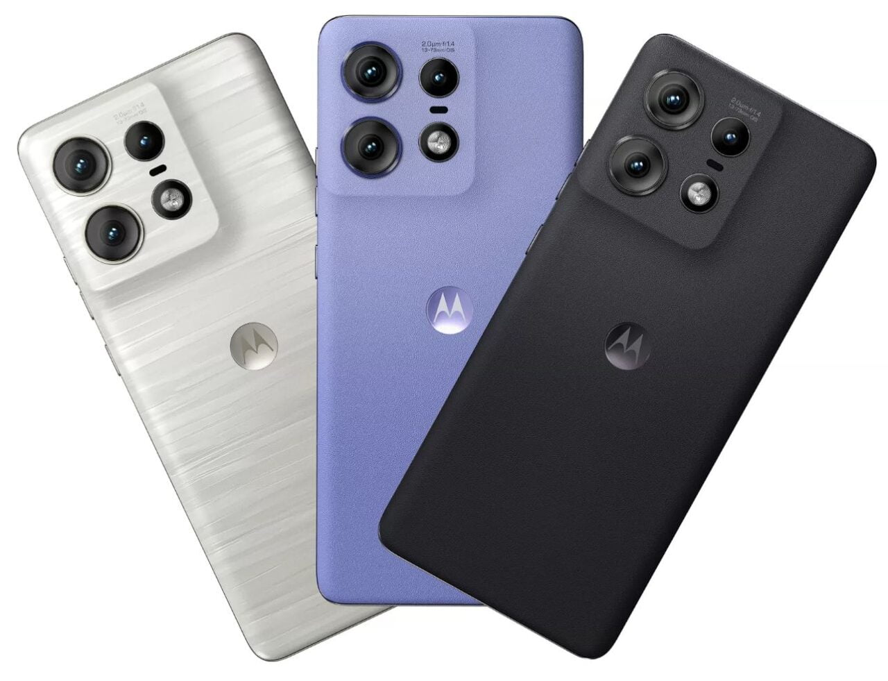 Trzy smartfony marki Motorola układane diagonalnie, z aparatem o potrójnym obiektywie, w kolorach białym, fioletowym i czarnym.