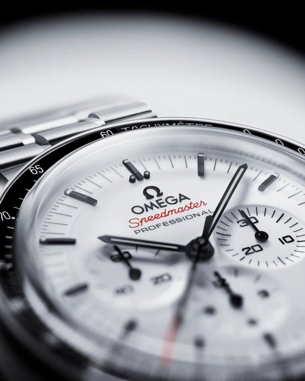 Zegarek Omega Speedmaster z białą tarczą, czarnymi wskazówkami i czerwonym akcentem na sekundniku, bransoletą z metalu.