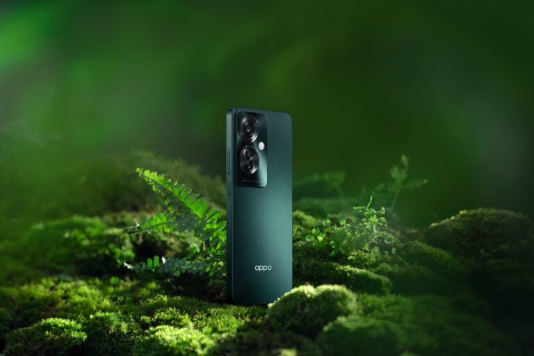 Smartfon OPPO Reno11 F 5G w zielonej odmianie z designem Oppo Glow pośród natury.