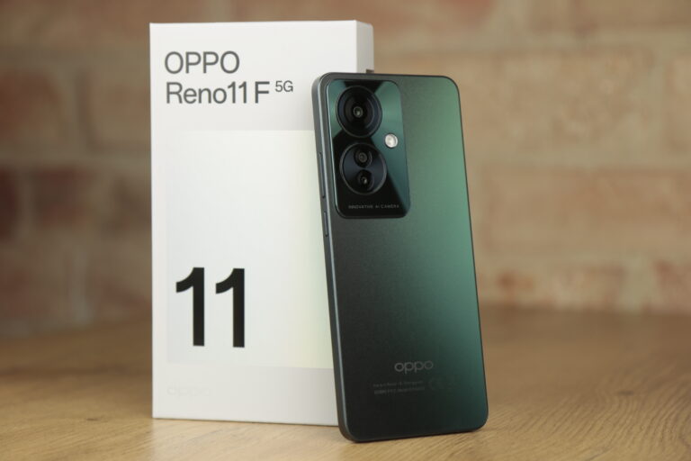 Smartfon OPPO Reno11 5G w kolorze zielonym z tyłu, z podwójnym aparatem, położony obok pudełka z logo i nazwą modelu.