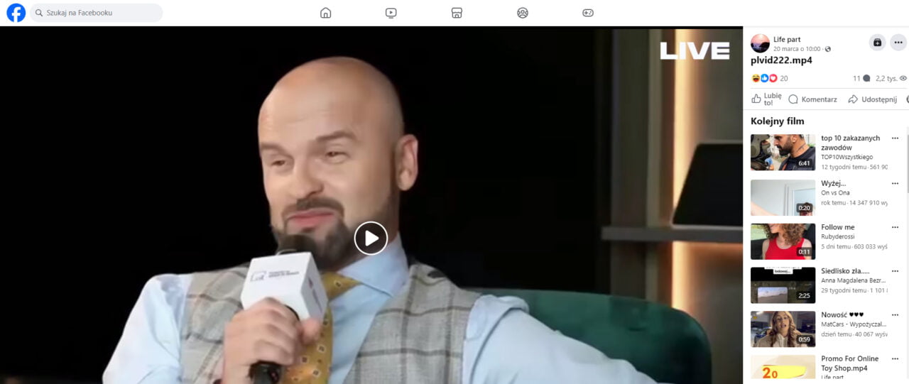 Oszustwo na Facebooku. Rafał Brzoska przemawiający do mikrofonu w trakcie transmisji na żywo, ubrany w jasną koszulę i żółty krawat, siedzi na zielonym fotelu.
