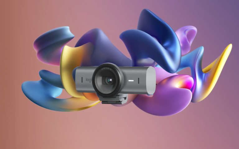 Kamera internetowa marki Logitech umieszczona przed abstrakcyjnym, kolorowym tłem przypominającym rozmyte płatki kwiatów.