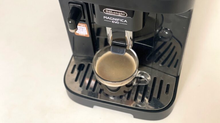 Ekspres do kawy DeLonghi Magnifica EVO z przygotowywaną filiżanką espresso.