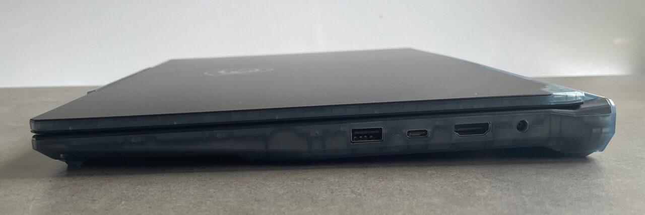 Zamknięty laptop Dell z widocznymi portami na boku, umieszczony na płaskiej powierzchni.