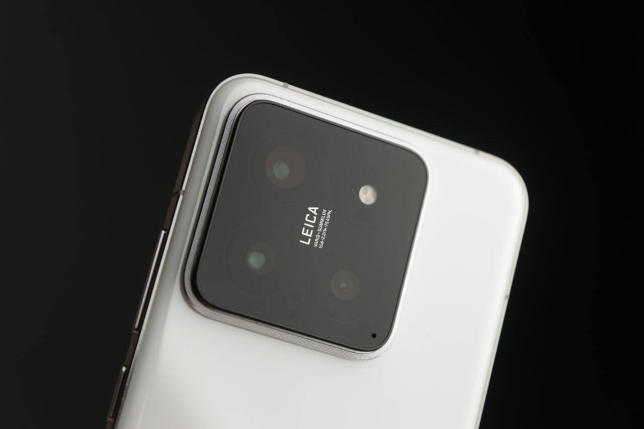 Biały smartfon z aparatem fotograficznym z czterema obiektywami i logo Leica na czarnym tle.