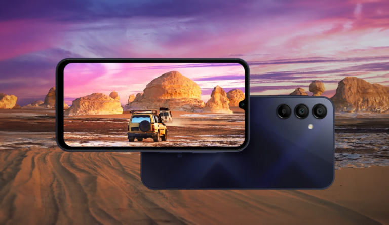 Smartfon z wyświetlaczem przedstawiającym terenoffowy samochód w pustynnym krajobrazie, z tyłu urządzenie z potrójnym układem aparatu.
