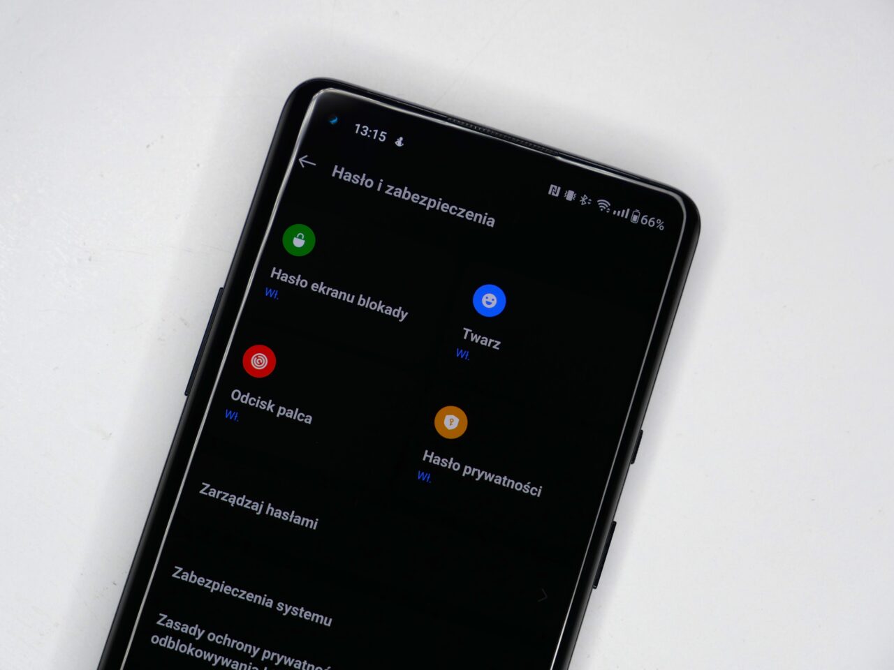 Smartfon wyświetlający menu ustawień bezpieczeństwa z opcjami takimi jak hasło i zabezpieczenia, odblokowywanie twarzy i odcisk palca.