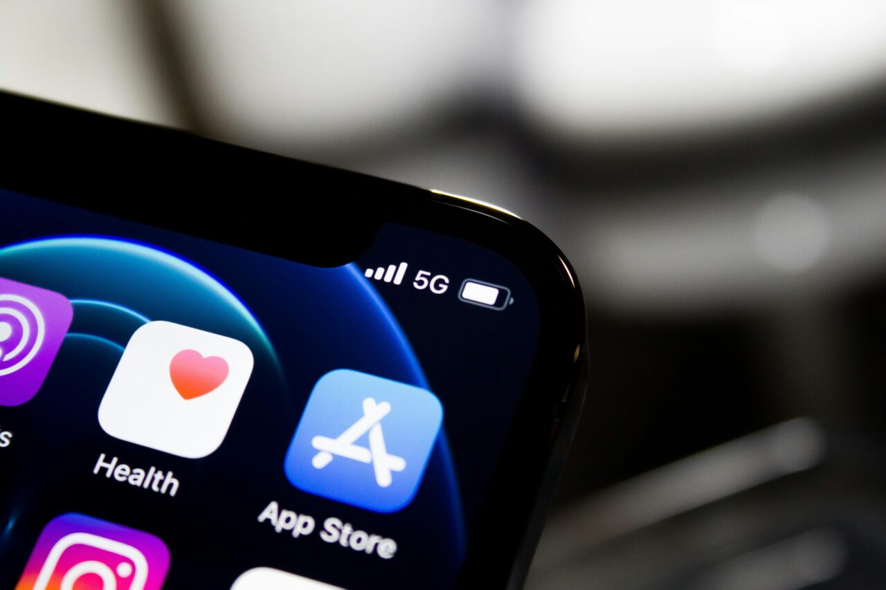 Zbliżenie na ekran smartfona wyświetlającego ikony aplikacji takie jak Zdrowie i App Store, z widocznym symbolem 5G i wskaźnikiem baterii w prawym górnym rogu.