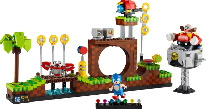Zestawy LEGO dla graczy przedstawiające scenę z gry Sonic the Hedgehog z figurką Sonica, złotymi pierścieniami, zielonym Drzewem, wrogim robotem, postacią Doktora Eggmana na platformie i innymi elementami nawiązującymi do gry.
