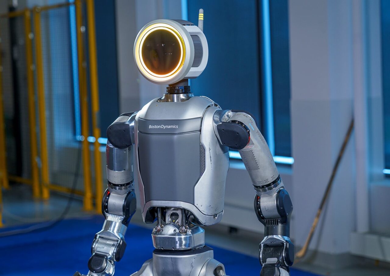 Robot Boston Dynamics stojący w pomieszczeniu z niebieskim oświetleniem.
