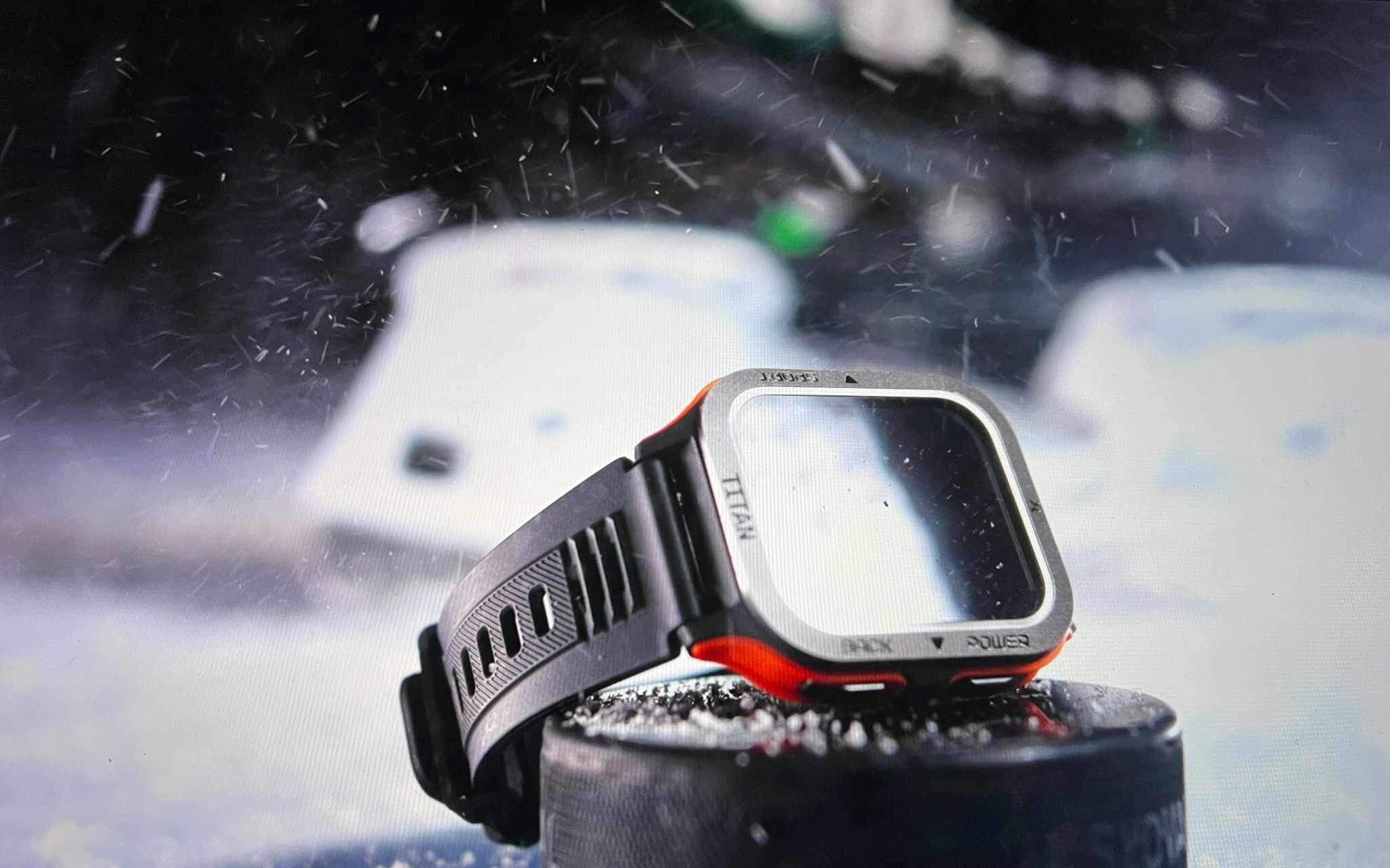 Smartwatch Maxcom FW67 Titan Pro na tle zamazanych samochodów podczas lekkiego opadu śniegu.