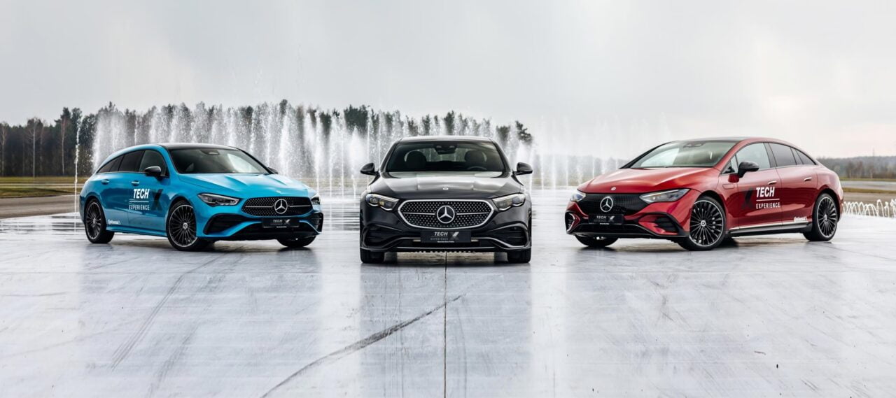Trzy samochody Mercedes-Benz w różnych kolorach ustawione na płycie betonowej z fontannami w tle.