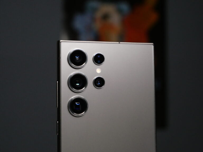 Tylna część smartfona z srebrnym wykończeniem, wyposażonego w czterokrotny układ aparatów fotograficznych i lampę błyskową.
