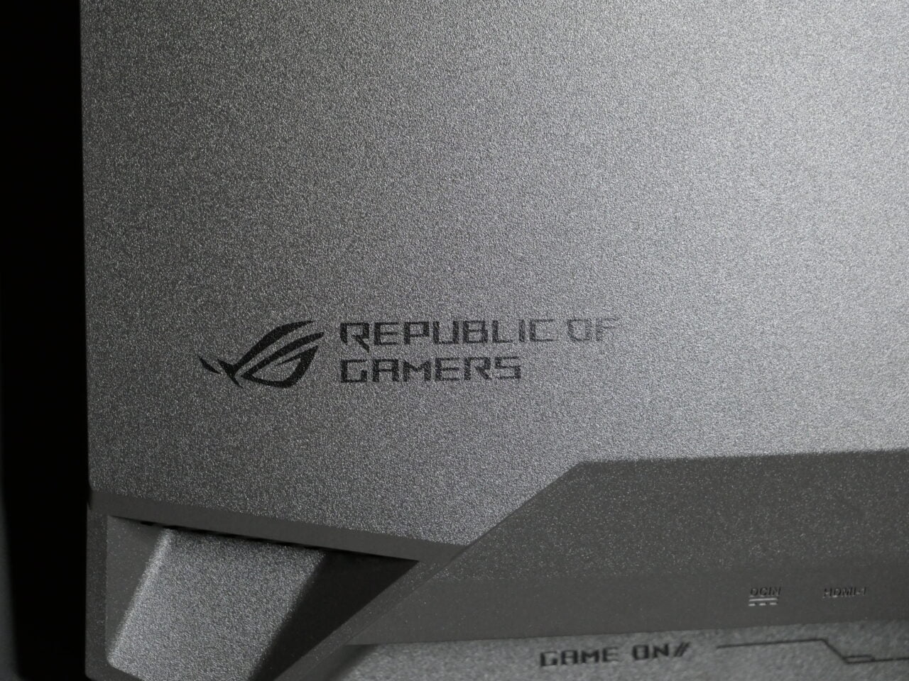 Zbliżenie na teksturę i logo "Republic of Gamers" na urządzeniu elektronicznym.