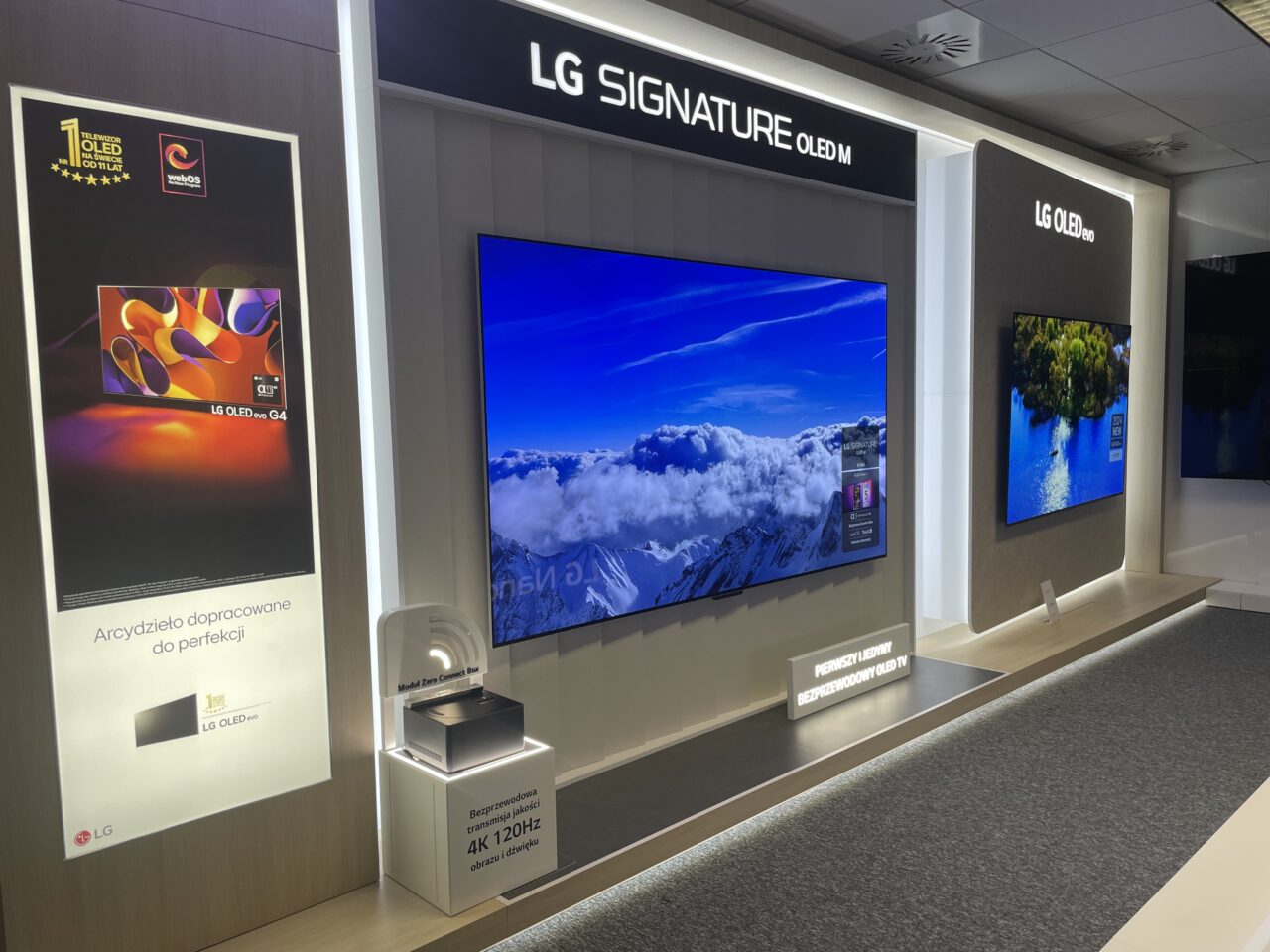 Stoisko LG z trzema telewizorami OLED prezentującymi różne obrazy oraz opisami funkcji i nagród.