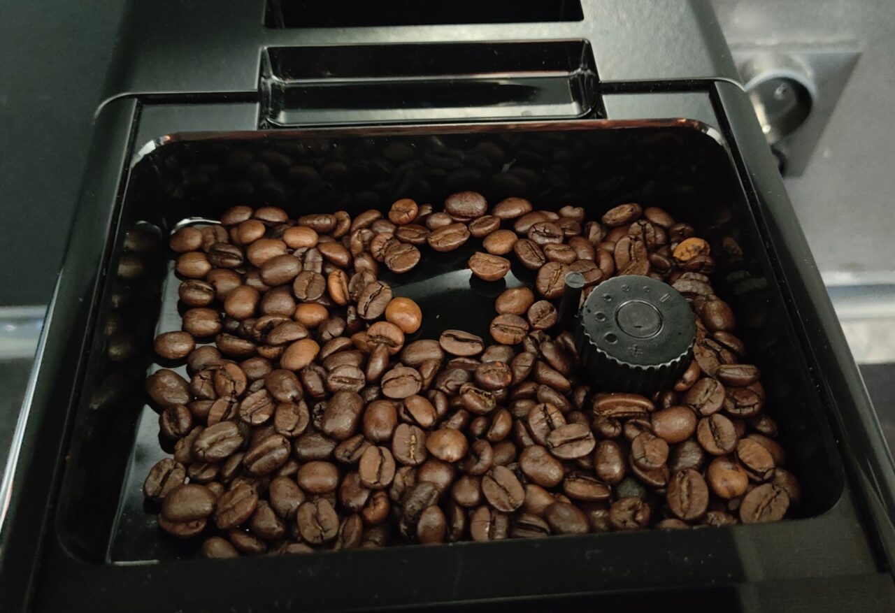 Komora młynek do kawy wypełniona ziarnami kawy.