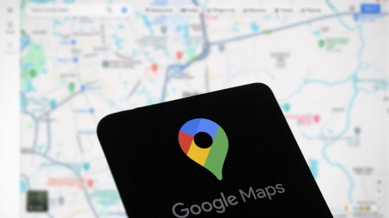 Smartfon z wyświetlonym logo Google Maps na pierwszym planie oraz rozmytą mapą w tle. Brak mapy w Google Maps nie jest już problemem