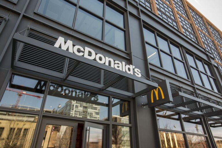 Widok na budynek restauracji McDonald's z dużym logo na zewnętrznej fasadzie.