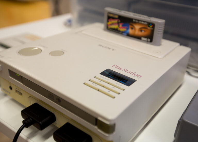 Biała konsola do gier Nintendo PlayStation z włożoną grą.