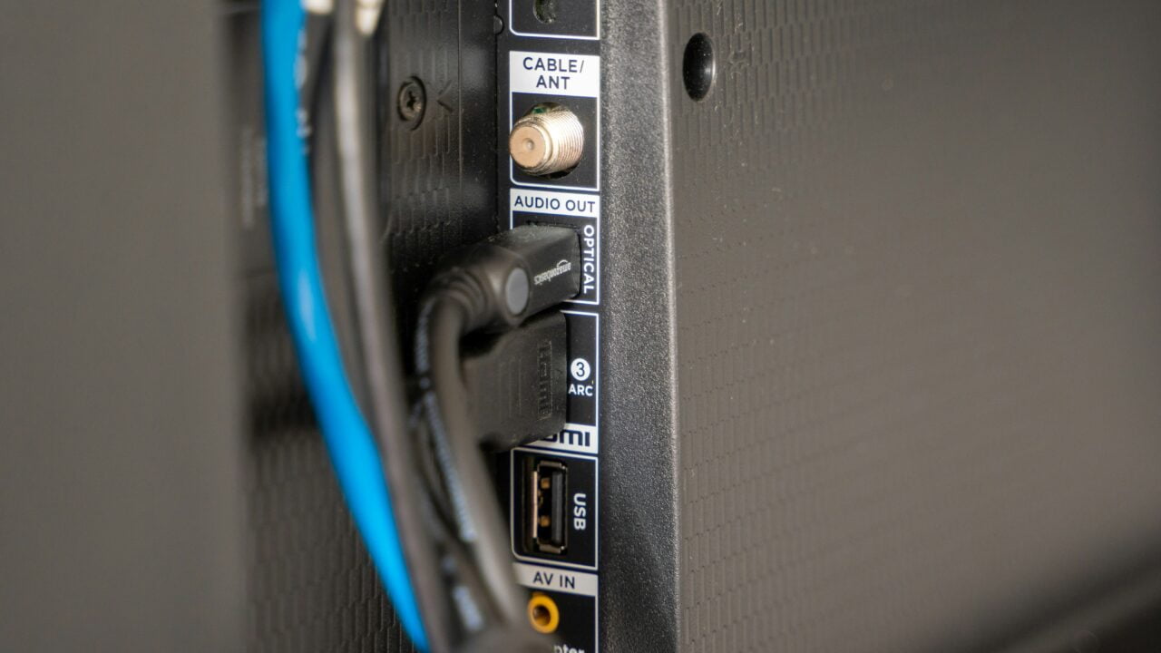 Panel z tyłu telewizora z podłączonymi kablami, w tym kablem HDMI do port HDMI i złączem antenowym.