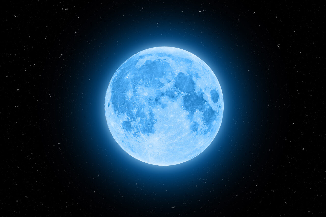 Niebieski księżyc na ciemnoniebieskim tle kosmosu z widocznymi gwiazdami.