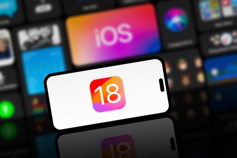 Smartfon z wyświetlonym logo systemu iOS 18 przed tłem z różnokolorowymi ikonami aplikacji.