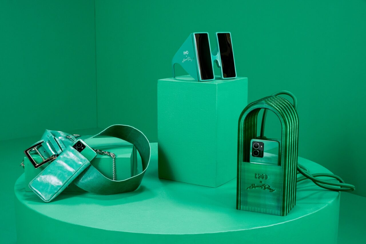 Zielony telefon, pasek, torebka i okulary przeciwsłoneczne na zielonym tle.