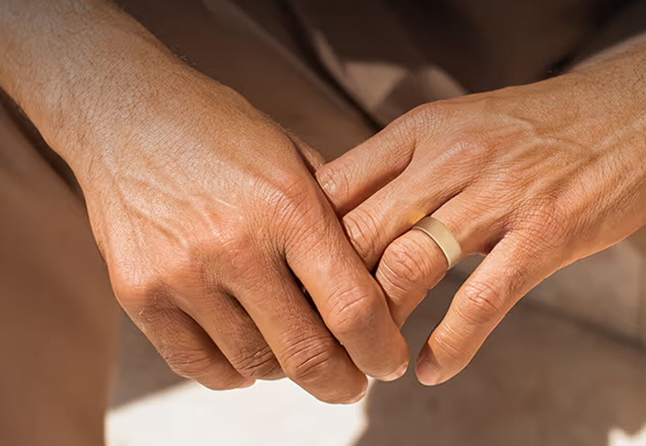 Zdjęcie splatających się dłoni z pierścieniem Amazfit Helio Ring na palcu.