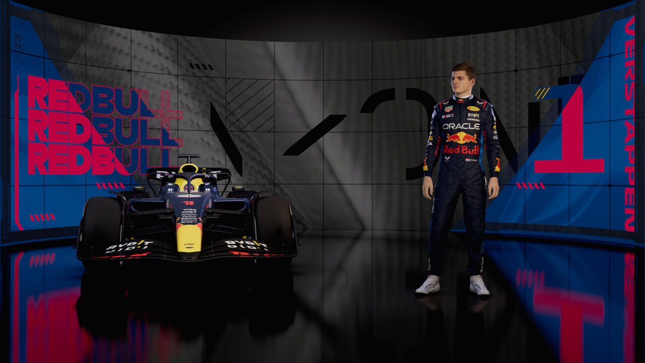 Kierowca wyścigowy w kombinezonie Red Bull Racing stojący obok samochodu wyścigowego na tle ekranu z logo Red Bull i numerem 1.
