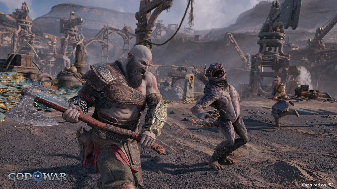 Scena z gry God of War Ragnarok na PC przedstawiająca Kratosa walczącego z potworem. W tle różne ruiny i konstrukcje. Po prawej stronie młody chłopak również przygotowuje się do walki.