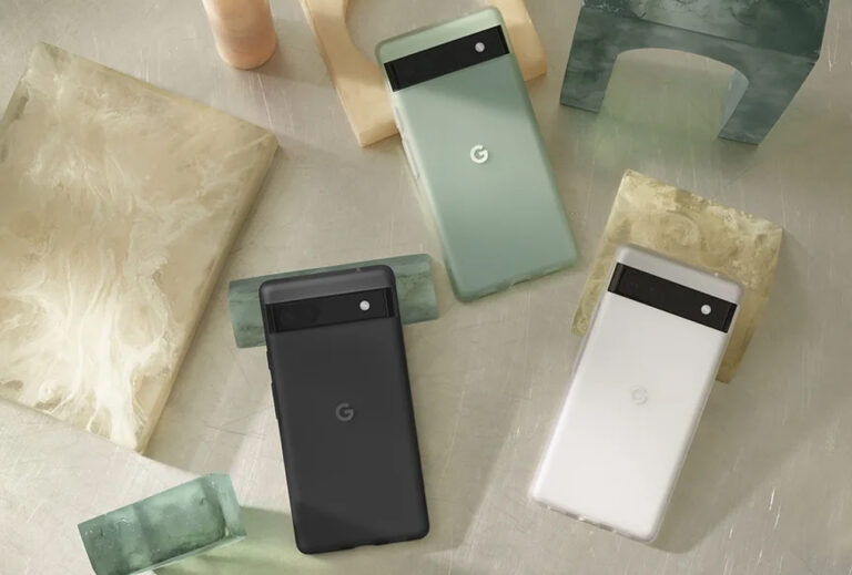 Smartfony Google Pixel 6a w różnych kolorach leżące na kamiennych płytach o różnych odcieniach i fakturach.