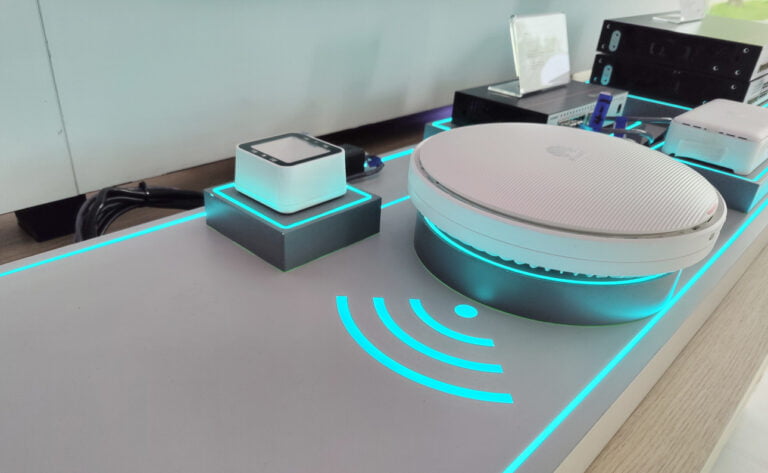 Stół z nowoczesnymi gadżetami technologicznymi i oświetleniem LED w modnym niebieskim kolorze.