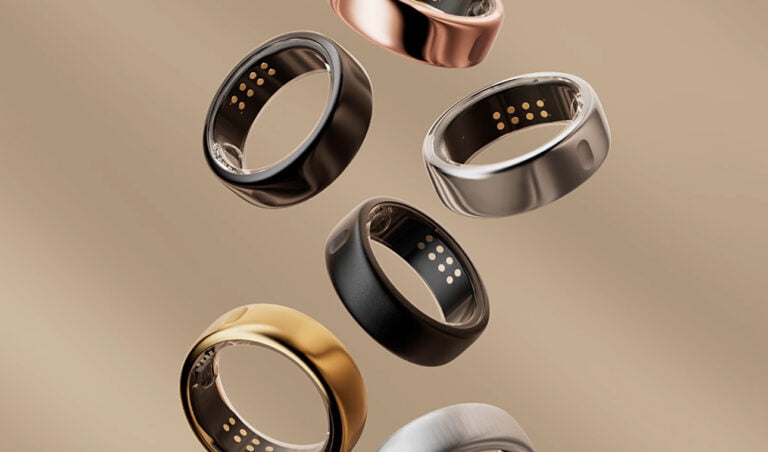 Kolekcja inteligentnych pierścieni Oura Ring w różnych kolorach na neutralnym tle.
