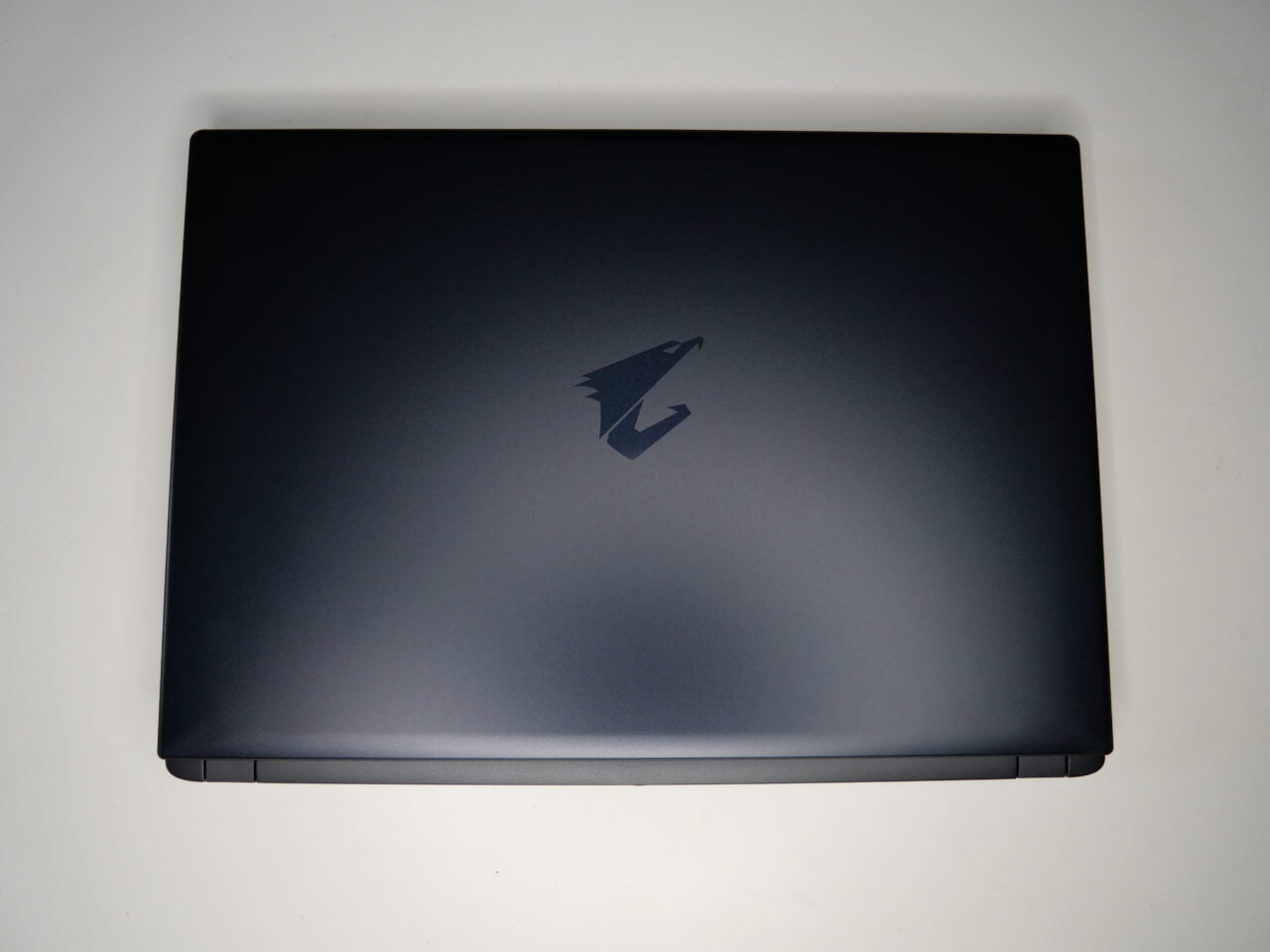 Zamknięty czarny laptop z logo na pokrywie.