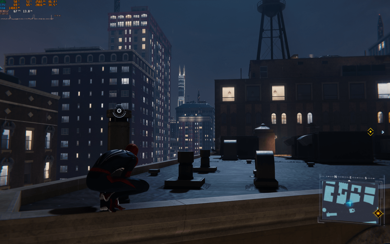 Bohater w stroju Spider-Mana kucający na dachu budynku w nocy, w tle widoczne są oświetlone wieżowce.