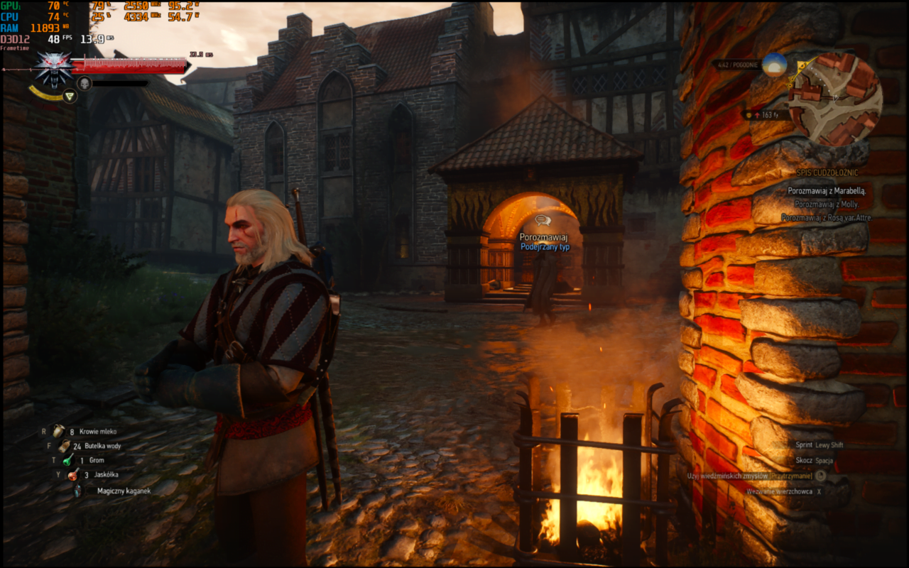 Postać z gry wideo "Wiedźmin 3: Dziki Gon" stoi obok ogniska na średniowiecznej ulicy. W tle widać kamienny budynek.