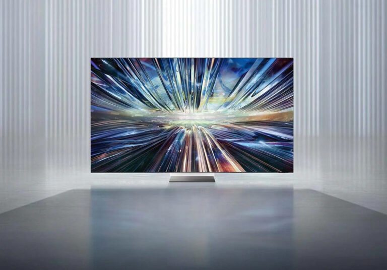 Telewizor Samsunga wyświetlający obraz abstrakcyjnej eksplozji światła i kolorów w minimalistycznym wnętrzu.