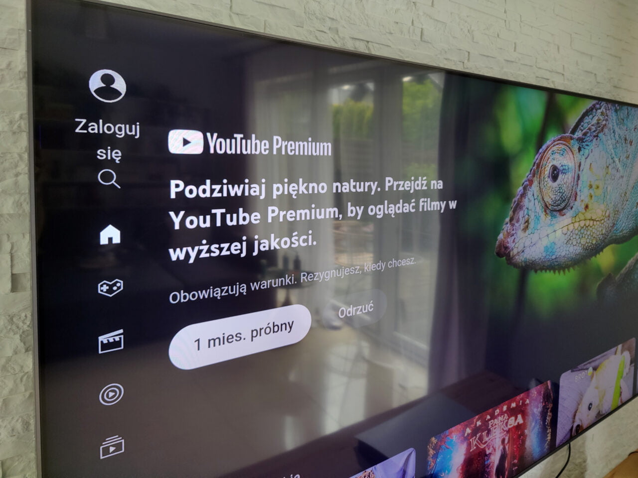 Ekran telewizora z interfejsem YouTube Premium i reklamą oferty próbnej z kameleonem po prawej stronie.