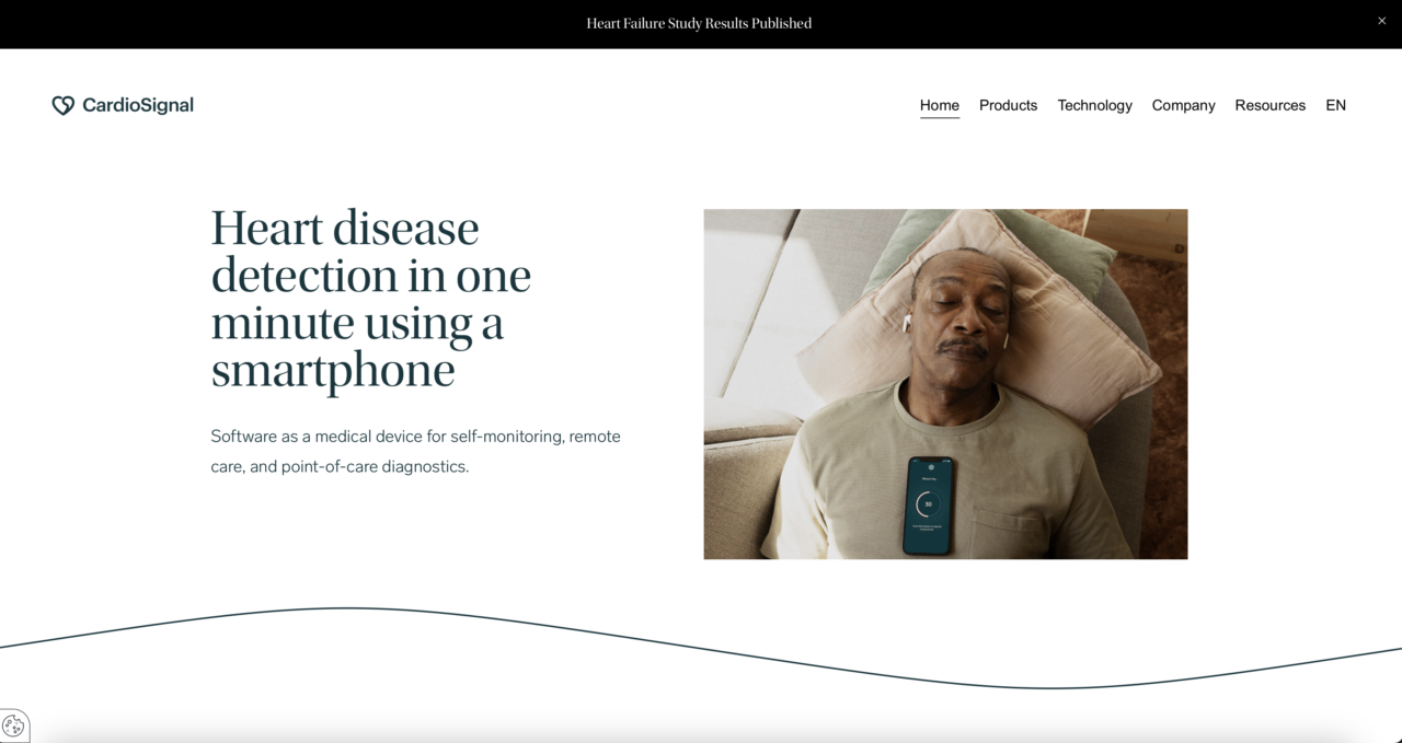 Starszy mężczyzna śpi na kanapie z telefonem komórkowym na klatce piersiowej, który wyświetla aplikację do monitorowania zdrowia. Technologia żyrokardiografii pozwoli wykryć niewydolność serca.