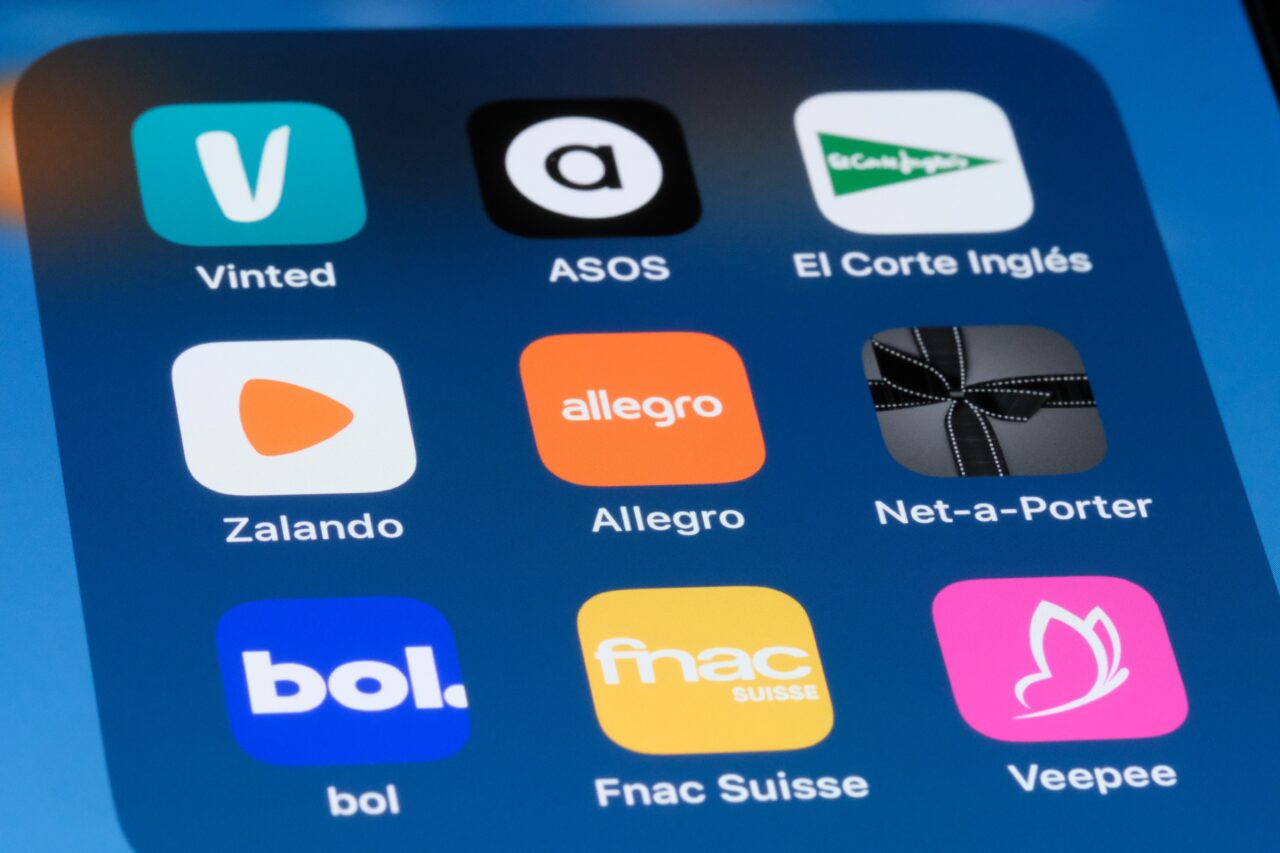 Ikony aplikacji Vinted, ASOS, El Corte Inglés, Zalando, Allegro, Net-a-Porter, bol, Fnac Suisse i Veepee na ekranie smartfona.
