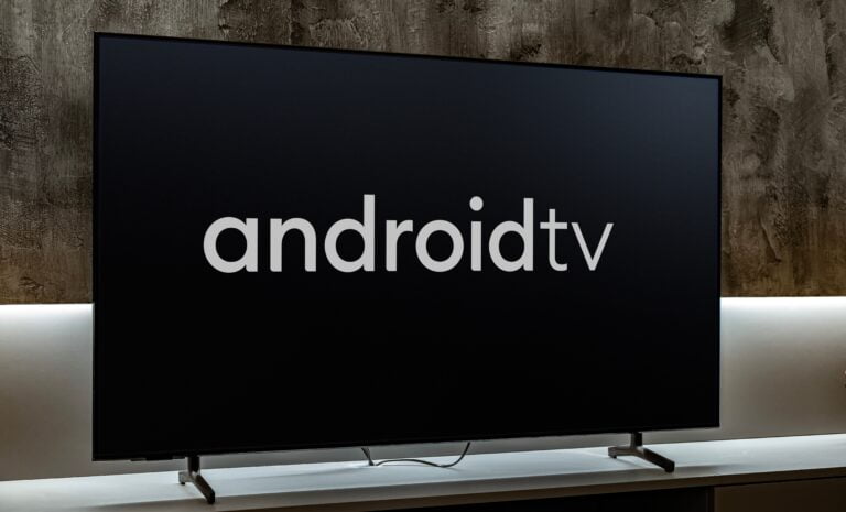 Telewizor z logo Android TV 14 na ekranie, ustawiony na półce.