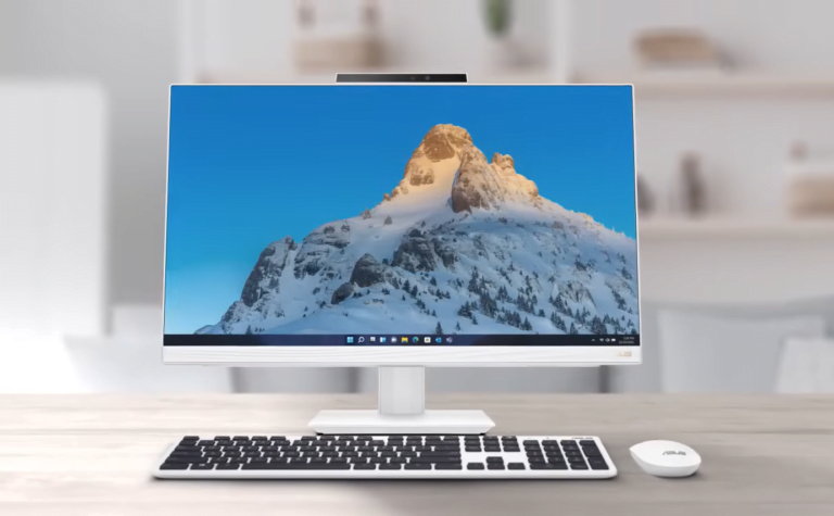 Monitor komputerowy na biurku z wyświetlonym obrazem zaśnieżonej góry.
