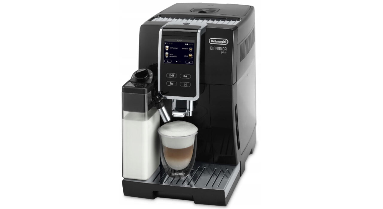 Ekspres do kawy DeLonghi Dinamica Plus z pojemnikiem na mleko i filiżanką cappuccino.