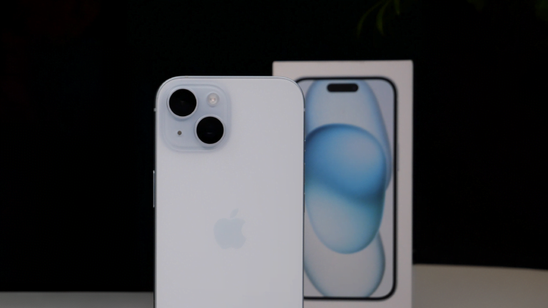 Biały iPhone z podwójnym aparatem z tyłu, na tle opakowania.