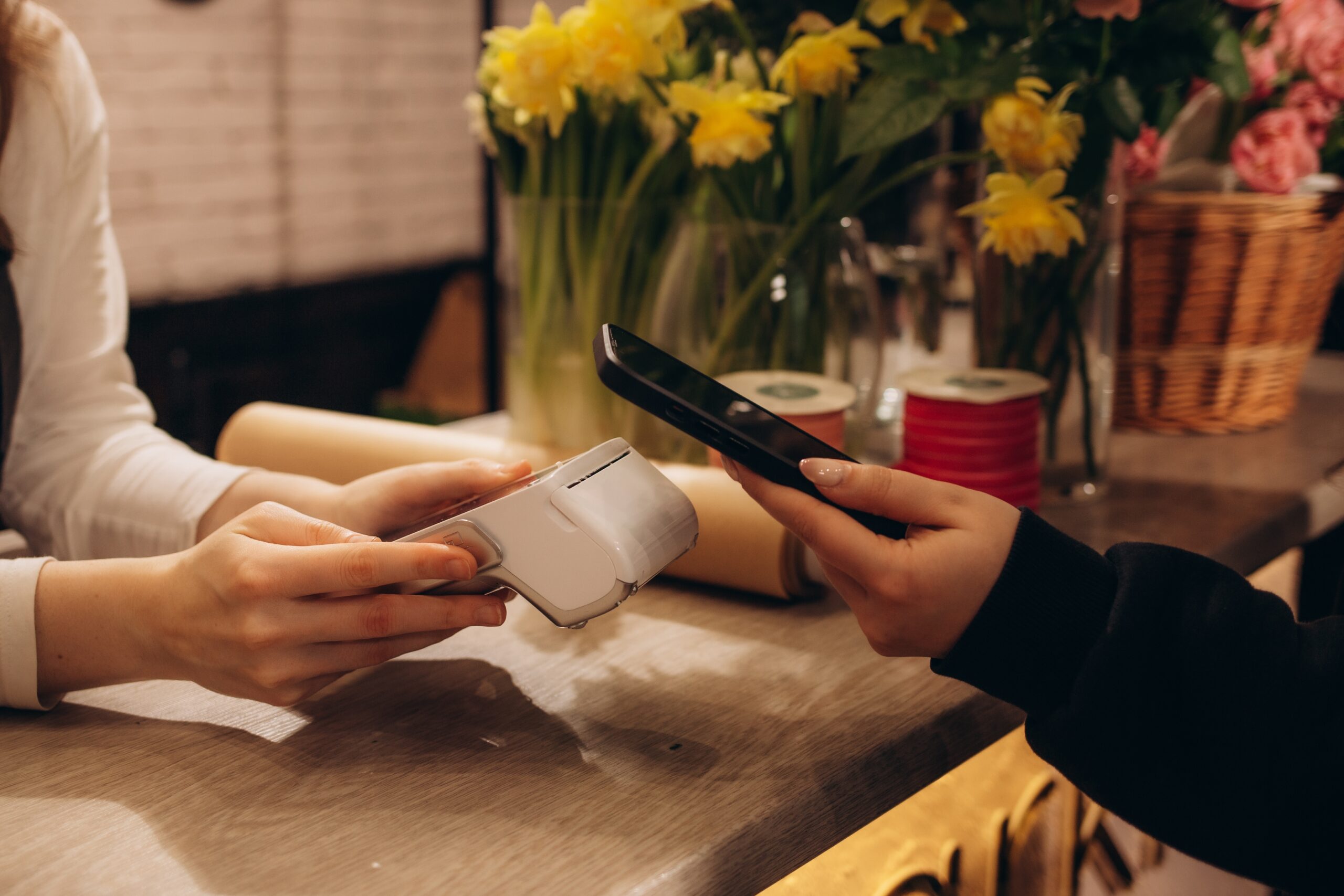 Płatność telefonem za pomocą terminala kart płatniczych w kwiaciarni. Gotówka jest tu rzadko przyjmowana.