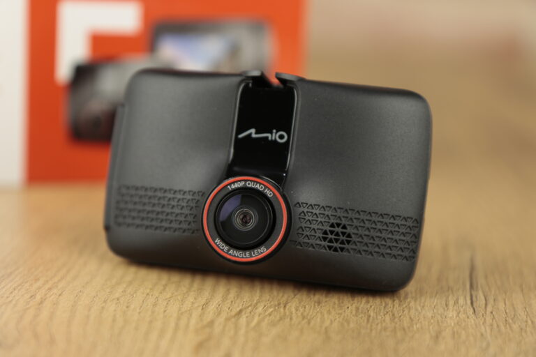Kamera samochodowa Mio 1440P Quad HD z szerokokątnym obiektywem na drewnianym stole.