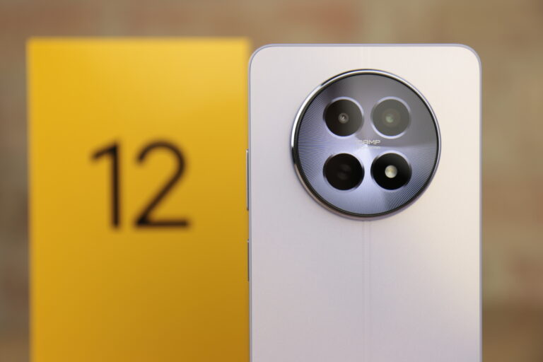 Trzy obiektywy aparatu fotograficznego smartfona realme 12 5G z napisem "108MP" na metalowym kole, znajdujące się na białym tle z rozmytym żółtym numerem 12.
