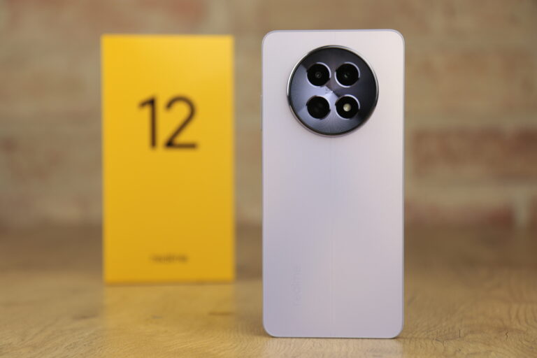 Recenzowany telefon realme 12 5G na białym tle obok żółtego pudełka z numerem 12.