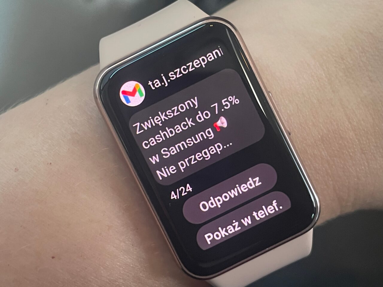 Smartwatch z wyświetlanym powiadomieniem o zwiększonym cashbacku na ekranie, noszony na nadgarstku.