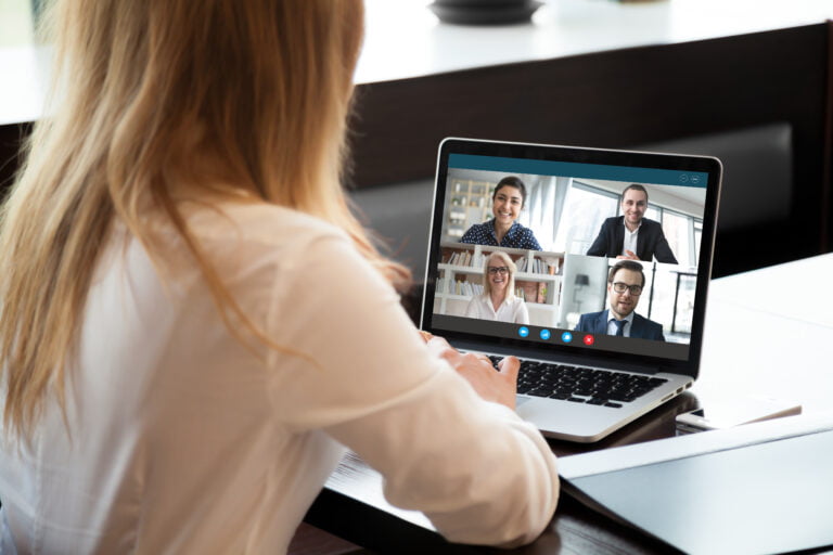 Osoba uczestnicząca w wideorozmowie z czterema osobami na ekranie laptopa.